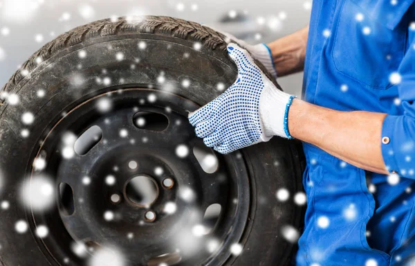 Close-up de mecânico de automóveis com pneu de carro — Fotografia de Stock