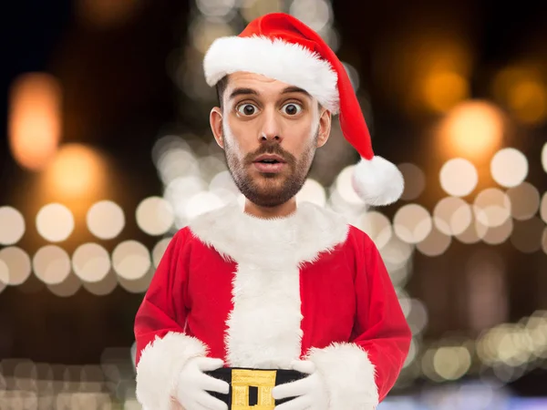 Человек в костюме Санта-Клауса за рождественскими огнями — стоковое фото