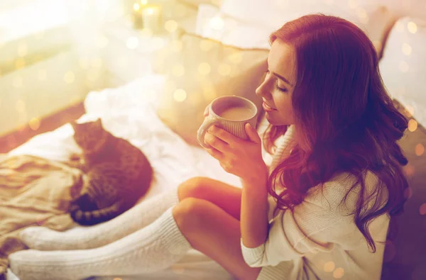 Ευτυχισμένη γυναίκα με καφέ στο κρεβάτι στο σπίτι Φωτογραφία Αρχείου