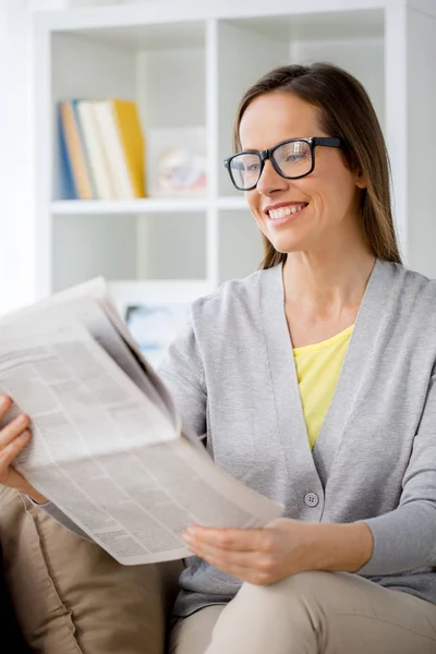 Mulher em óculos ler jornal em casa — Fotografia de Stock