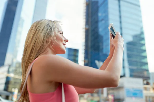 Young woman with smartphone photographing city — Stock Photo, Image