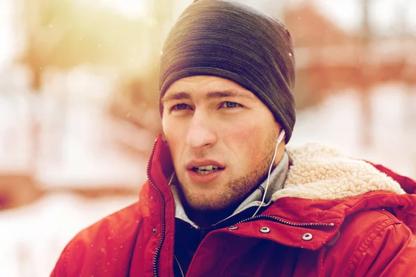 Man with earphones listening to music in winter — Stock Photo, Image