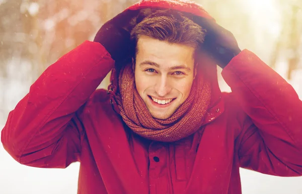 Gelukkig man in winter jas met kap buitenshuis — Stockfoto