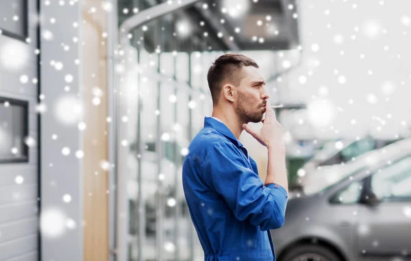 Auto mechanic smoking cigarette at car workshop — Stock Photo, Image