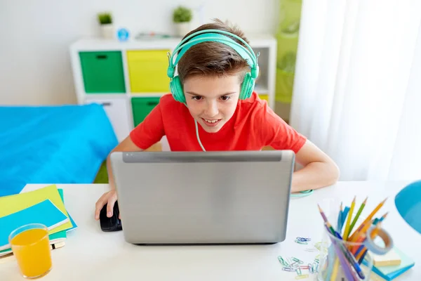Chłopiec w słuchawkach gra wideo na laptopie — Zdjęcie stockowe