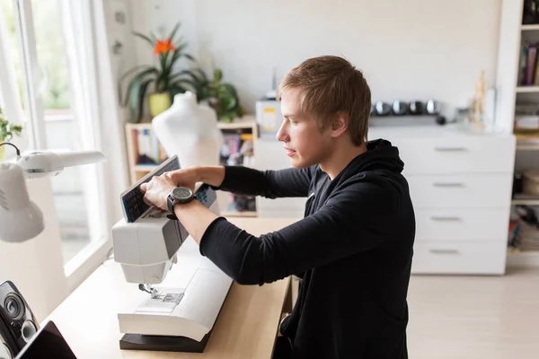Designer de moda com máquina de costura no estúdio — Fotografia de Stock