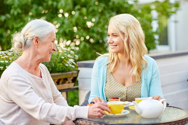 Hija con la madre mayor bebiendo té en la cafetería — Foto de Stock