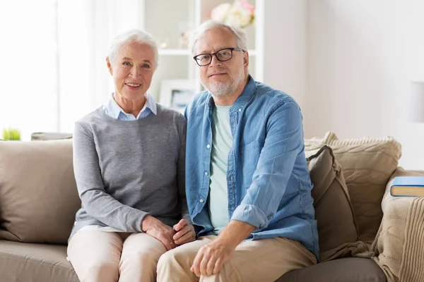 Feliz casal sênior sentado no sofá em casa — Fotografia de Stock