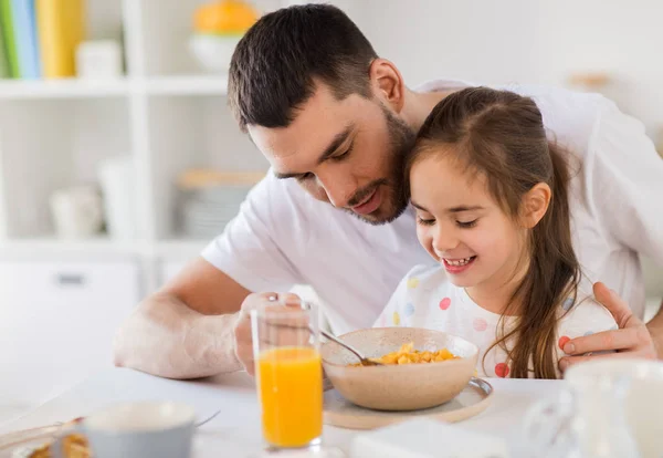 Lycklig familj äter flingor till frukost hemma — Stockfoto