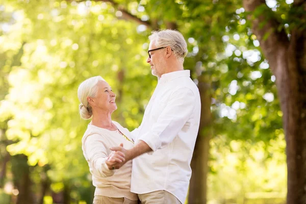 Счастливая пожилая пара танцует в летнем парке — стоковое фото