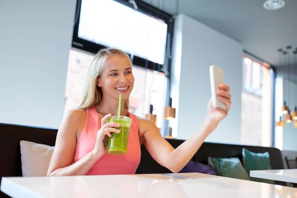 Woman with smartphone taking selfie at restaurant — Stock Photo, Image