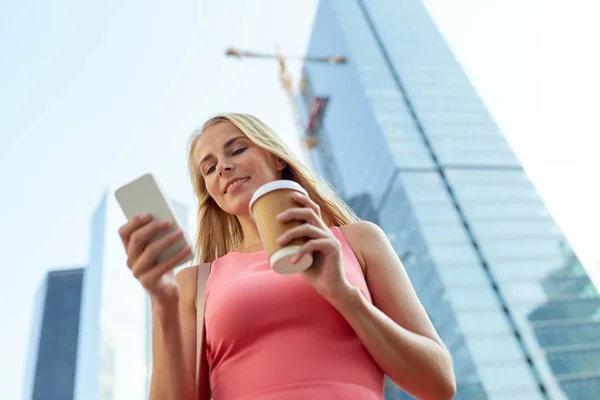 Mulher com café e smartphone na cidade — Fotografia de Stock