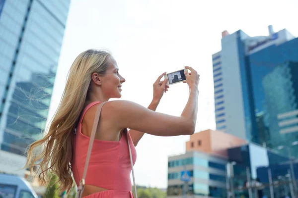 Young woman with smartphone photographing city — Stock Photo, Image