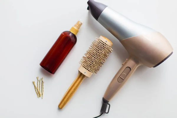 Secador de pelo, cepillo, spray y alfileres para el cabello de estilo caliente — Foto de Stock