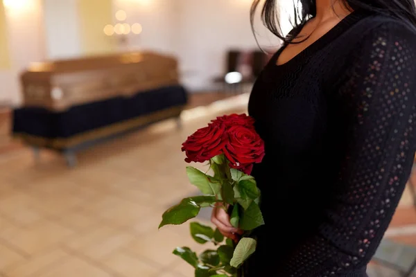 Primer plano de la mujer con rosas y ataúd en el funeral —  Fotos de Stock