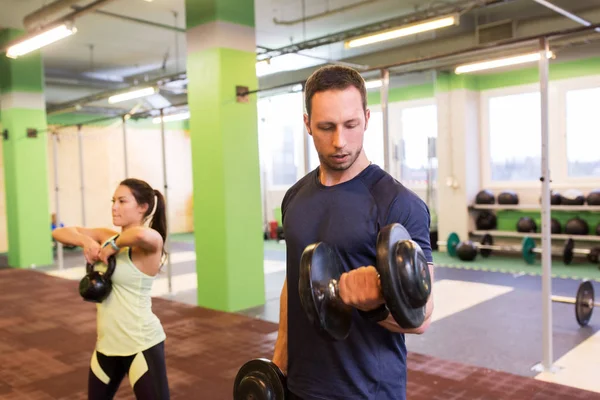 Man and woman with kettlebell exercising in gym — Stock Photo, Image