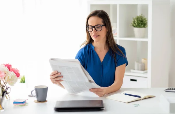Affärskvinna läsa tidningen på kontor — Stockfoto