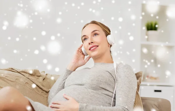 Zwangere vrouw met koptelefoon luisteren naar muziek — Stockfoto