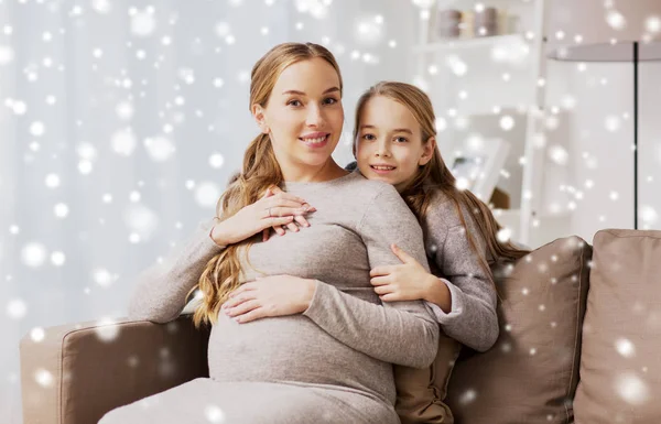快乐怀孕的妇女和女孩在家里拥抱 — 图库照片