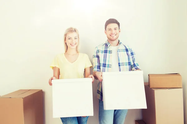 Sonriente pareja con grandes cajas moviéndose a nuevo hogar — Foto de Stock