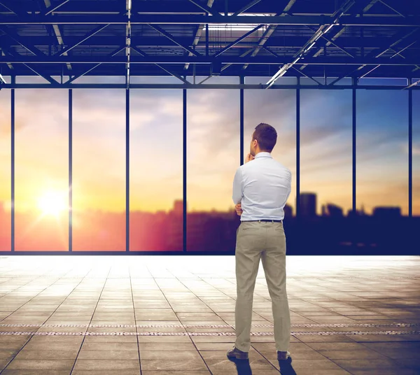 Homme d'affaires réfléchissant sur bureau et vue sur la ville — Photo