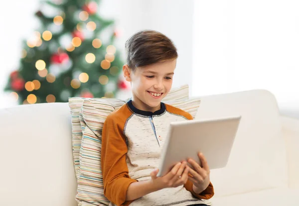 Niño sonriente con la tableta PC en casa en Navidad —  Fotos de Stock