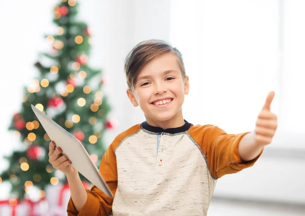 Menino com tablet pc mostrando polegares para cima no Natal — Fotografia de Stock