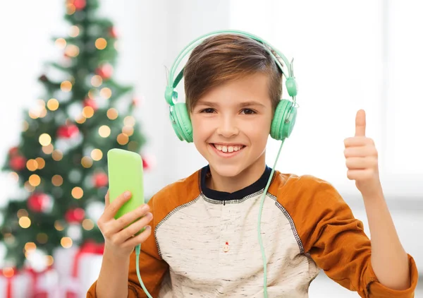 Niño con smartphone y auriculares en Navidad —  Fotos de Stock