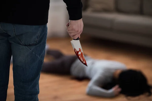 Criminal with knife and dead body at crime scene — Stock Photo, Image