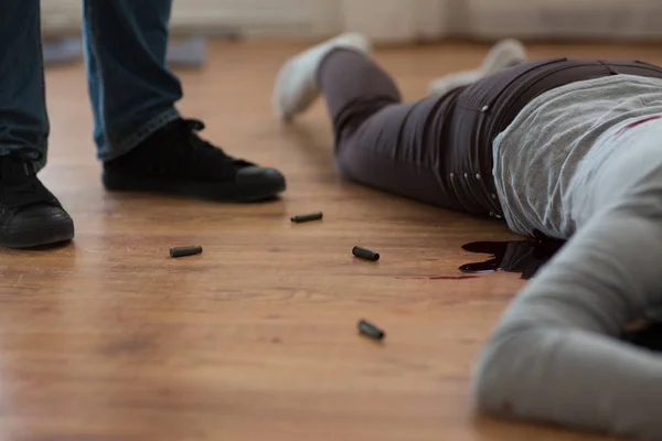 Criminal with dead body and bullets at crime scene — Stock Photo, Image