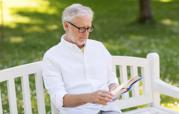 Hombre mayor leyendo libro en el parque de verano —  Fotos de Stock