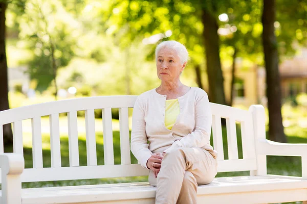 Θλιβερή ανώτερων γυναίκα που κάθεται στον πάγκο στο πάρκο καλοκαίρι — Φωτογραφία Αρχείου