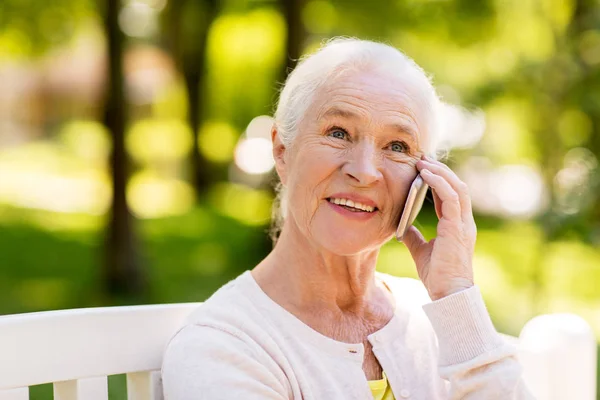 Щаслива старша жінка телефонує на смартфон влітку — стокове фото