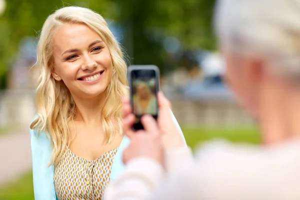 Senior mor fotografering dotter av smartphone — Stockfoto