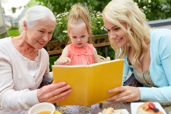 Lycklig familj läsebok på caféets terrass — Stockfoto
