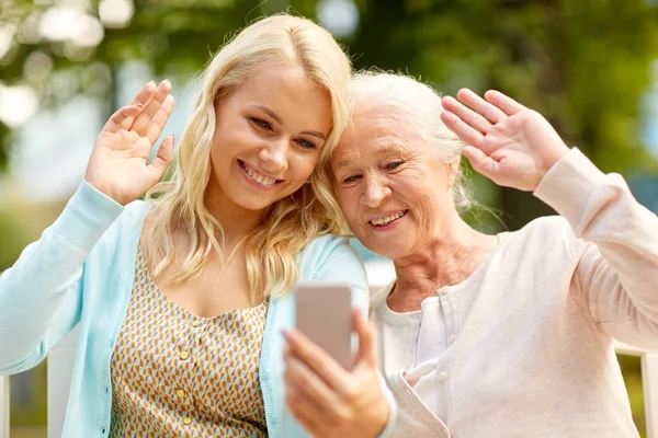 Daughter and senior mother taking selfie at park — Stock Photo, Image