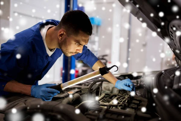 Mechanik mężczyzna z Lampa naprawy samochodu w warsztacie — Zdjęcie stockowe