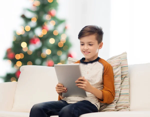 Menino sorridente com tablet pc em casa no Natal — Fotografia de Stock