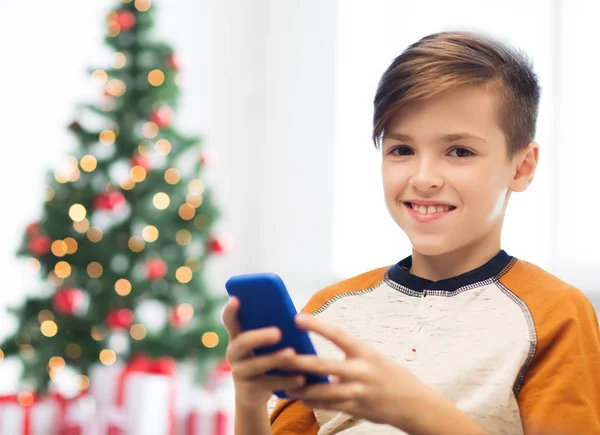 Primer plano de niño feliz con teléfono inteligente en Navidad — Foto de Stock