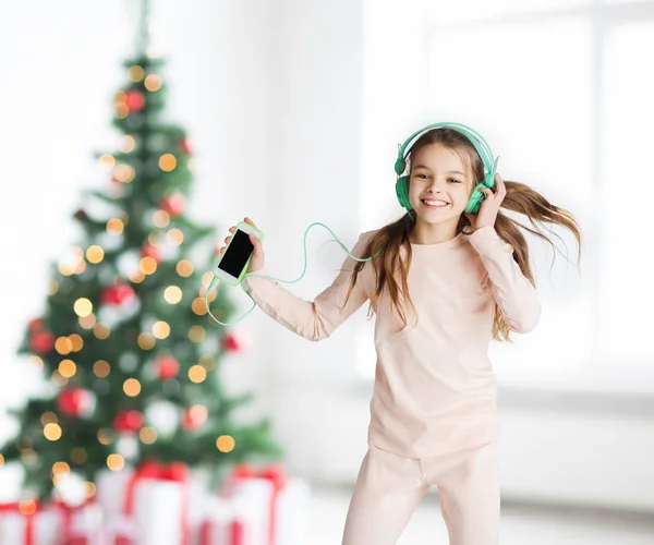 Dziewczyna z smartphone i słuchawki na Boże Narodzenie — Zdjęcie stockowe