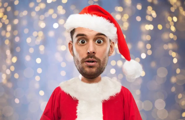 Mann im Weihnachtsmann-Kostüm über Weihnachtsbeleuchtung — Stockfoto