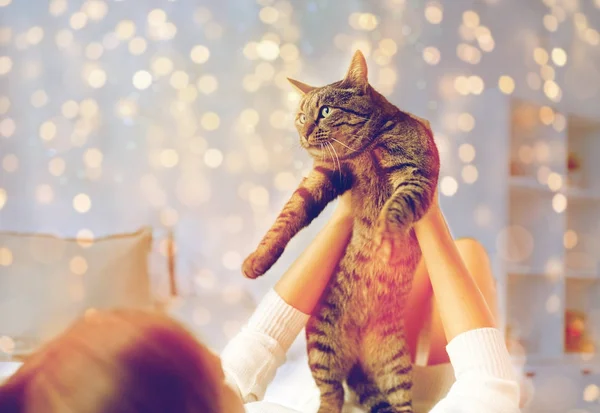 Jovem mulher com gato deitado na cama em casa — Fotografia de Stock