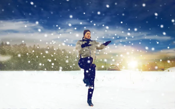 Muž cvičení a warmig se v zimě venku — Stock fotografie