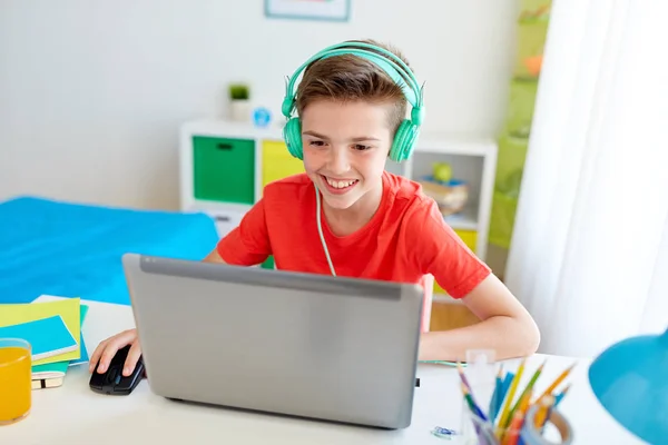 Αγόρι με ακουστικά που παίζει βιντεοπαιχνίδι στο laptop — Φωτογραφία Αρχείου
