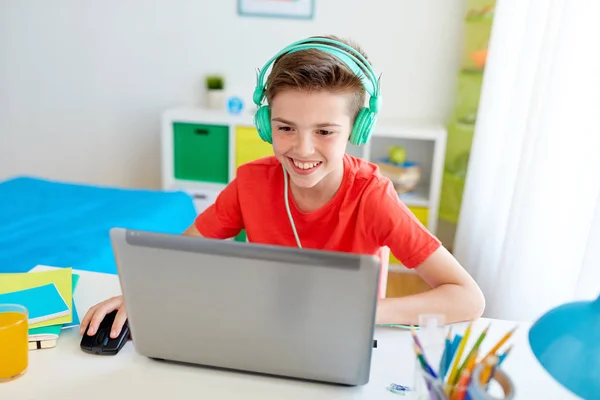 Jongen in hoofdtelefoon spelen video game op laptop — Stockfoto