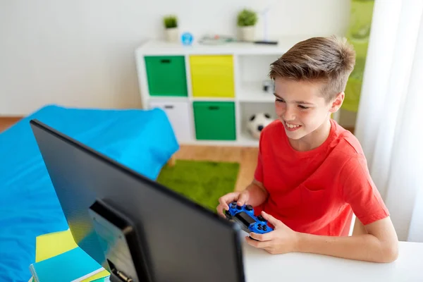 Pojke med gamepad spelar videospel på dator — Stockfoto