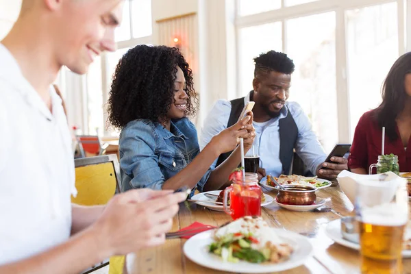 Mutlu arkadaş smartphones vasıl restoran grubu — Stok fotoğraf