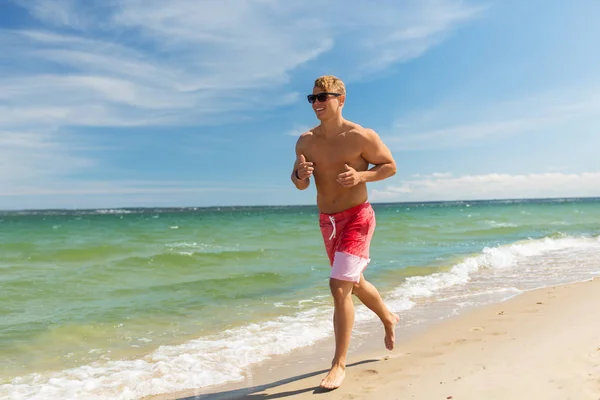 Happy man running along summer beach — Stock Photo, Image