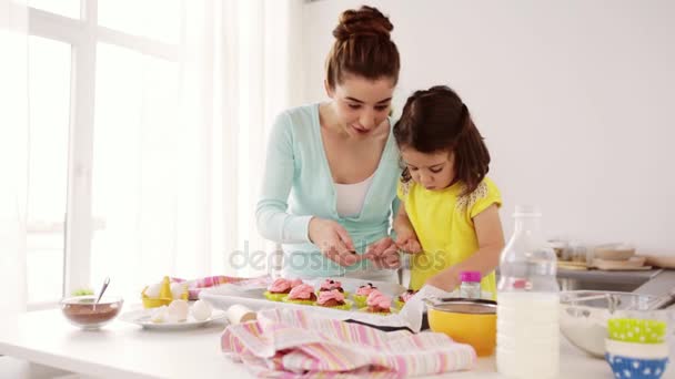 Мама и дочь готовят кексы дома — стоковое видео