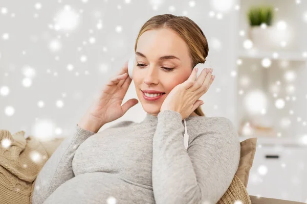 Zwangere vrouw met koptelefoon luisteren naar muziek — Stockfoto
